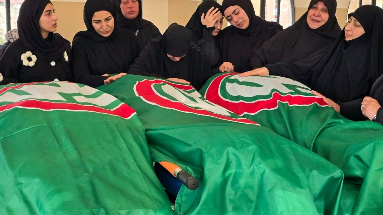 Mourners gather around the bodies of people killed earlier this week by Israeli airstrikes in the Lebanese coastal city of Tyre