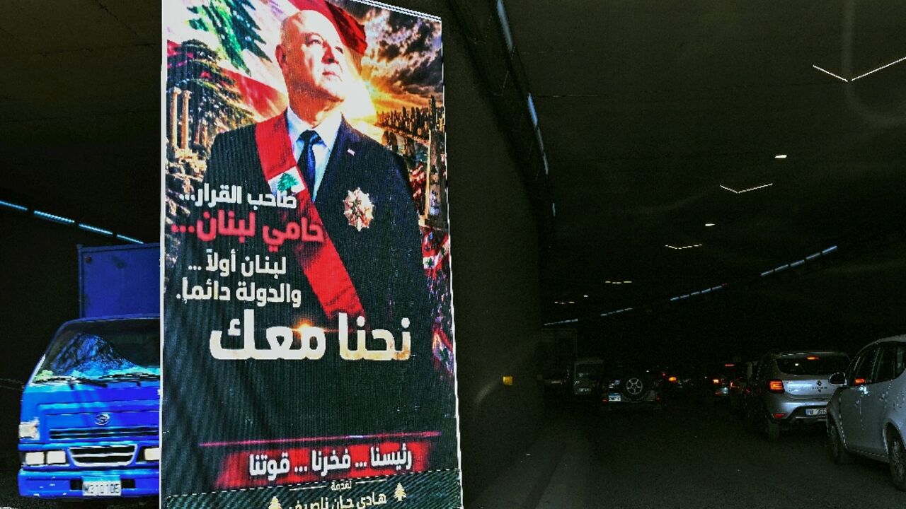 A poster depicting the portrait of Lebanon's President Joseph Aoun that reads "The decision-maker, the protector of Lebanon, Lebanon first...The State always. We are with you" hangs on a Beirut street