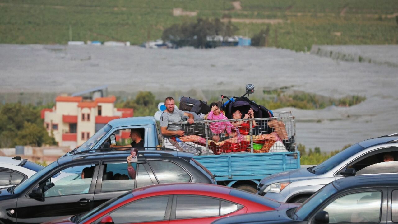 Displaced residents travel back to their homes via the bombed Qasmiyeh bridge over the Litani River 