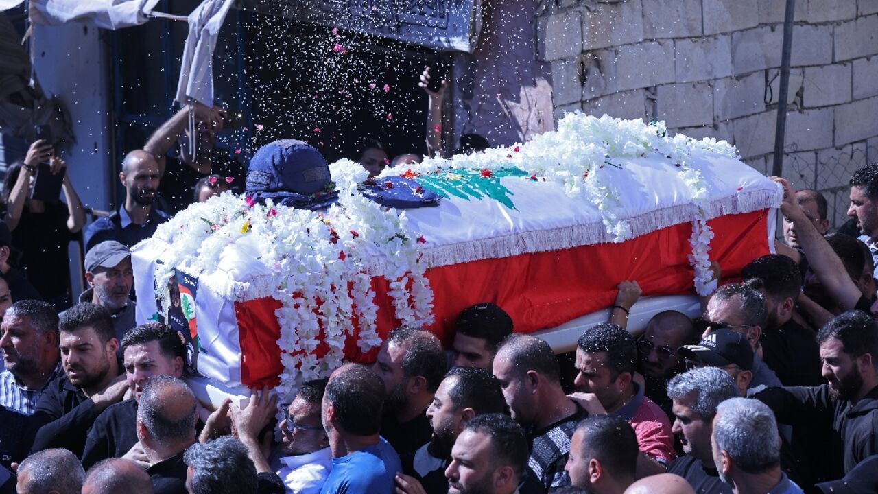 Mourners carry the coffin of Lebanese journalist Amal Khalil during her funeral procession in the southern town of  Bissariye