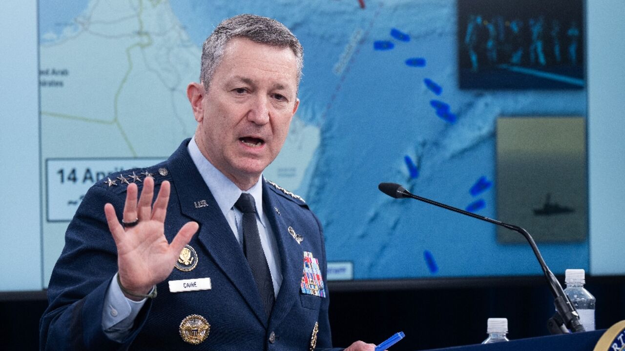 US Chairman of the Joint Chiefs of Staff General Dan Caine speaks as a map of the Strait of Hormuz is displayed during a press briefing