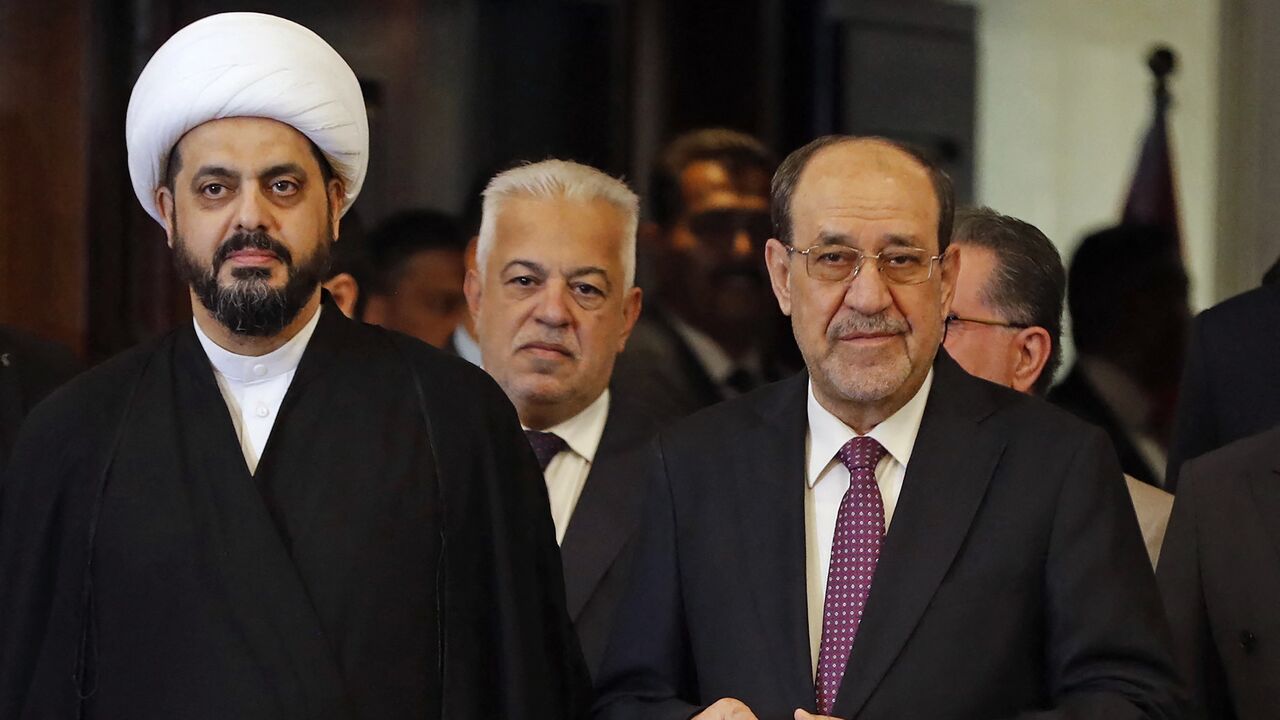 Qais al-Khazali (L), head of the Asaib Ahl al-Haq group, stands along with former Iraqi Prime Minister Nouri al-Maliki after casting their ballots at a polling station in Baghdad on Nov. 11, 2025.