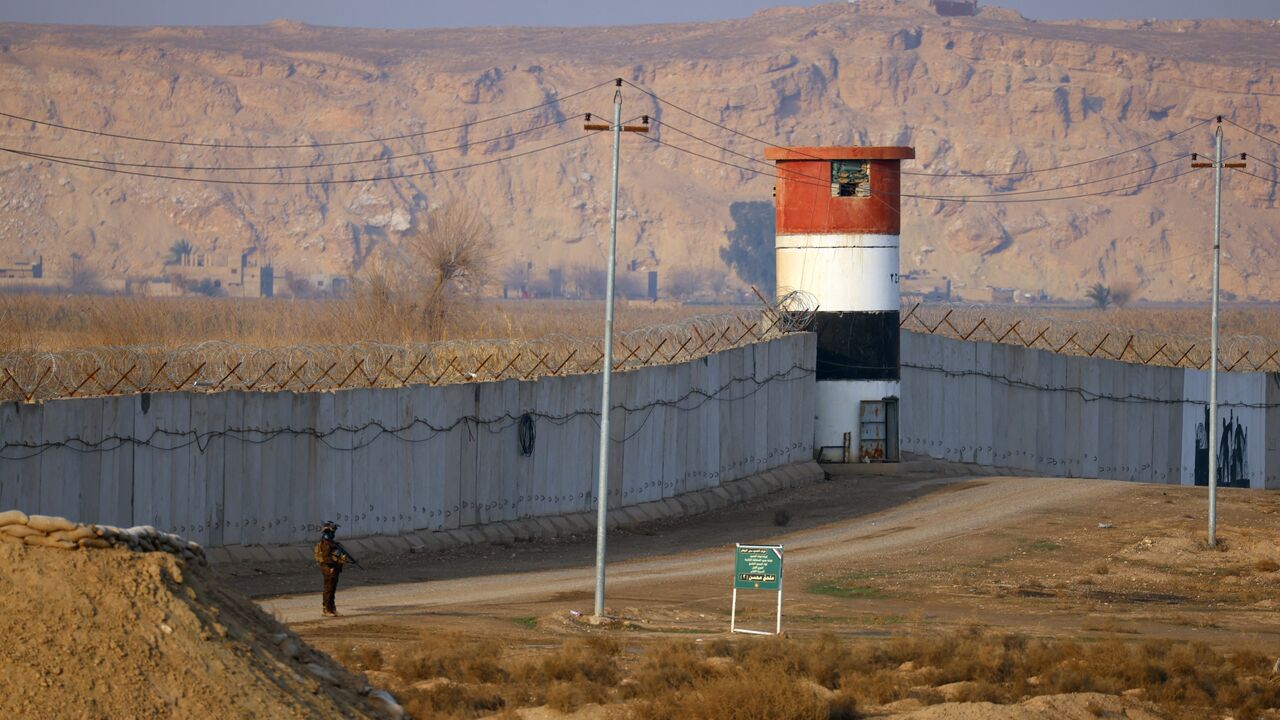 A member of the Popular Mobilization Forces patrols along a concrete wall at the Iraqi-Syrian border in Al-Qaim, west of Iraq, on Jan. 23, 2026. 