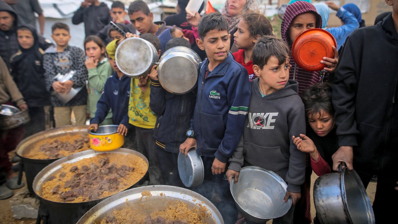 Children and families gather to receive free meals shortly before Iftar during the holy month of Ramadan at a displacement camp in central Gaza City, on Feb. 27, 2026.