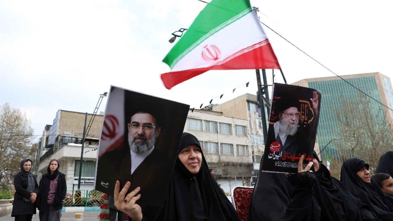 Iranian women hold portraits of Iran's supreme leader Mojtaba Khamenei (R) and  Iran’s slain supreme leader Ayatollah Ali Khamenei (L) while gathering in front of Tehran's Mellat park on April 2, 2026