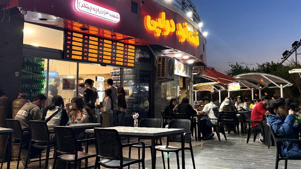 Iranians gather at an eatery in northwestern Tehran. Despite an outward appearance of normality, many are under severe financial strain