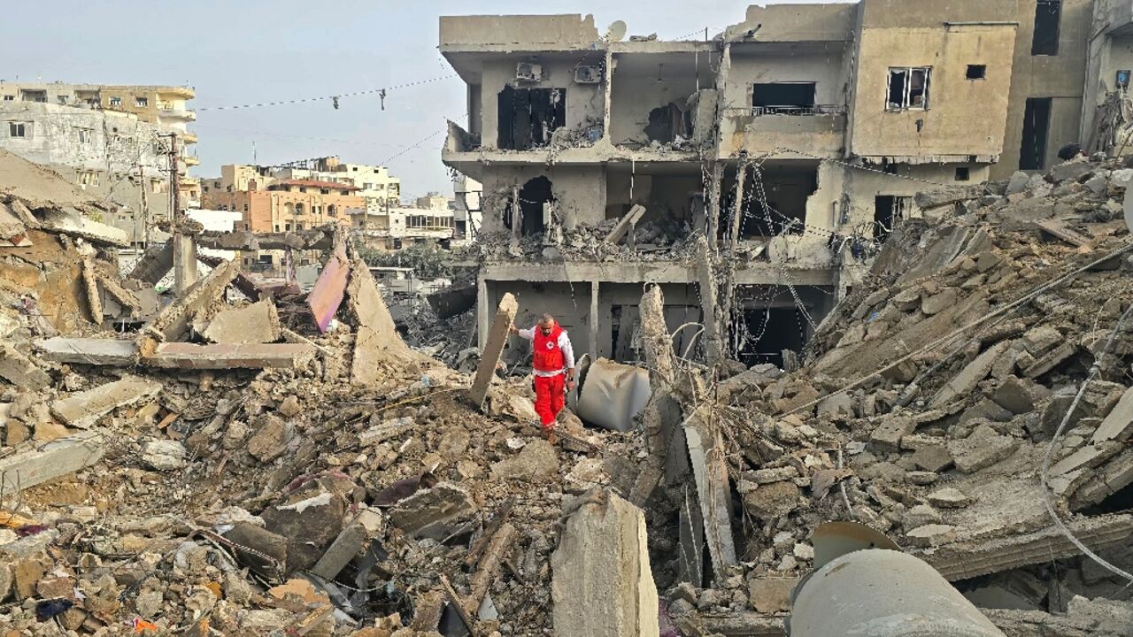 A rescue worker inspects the debris of destroyed buildings in the Maarakeh area near Tyre