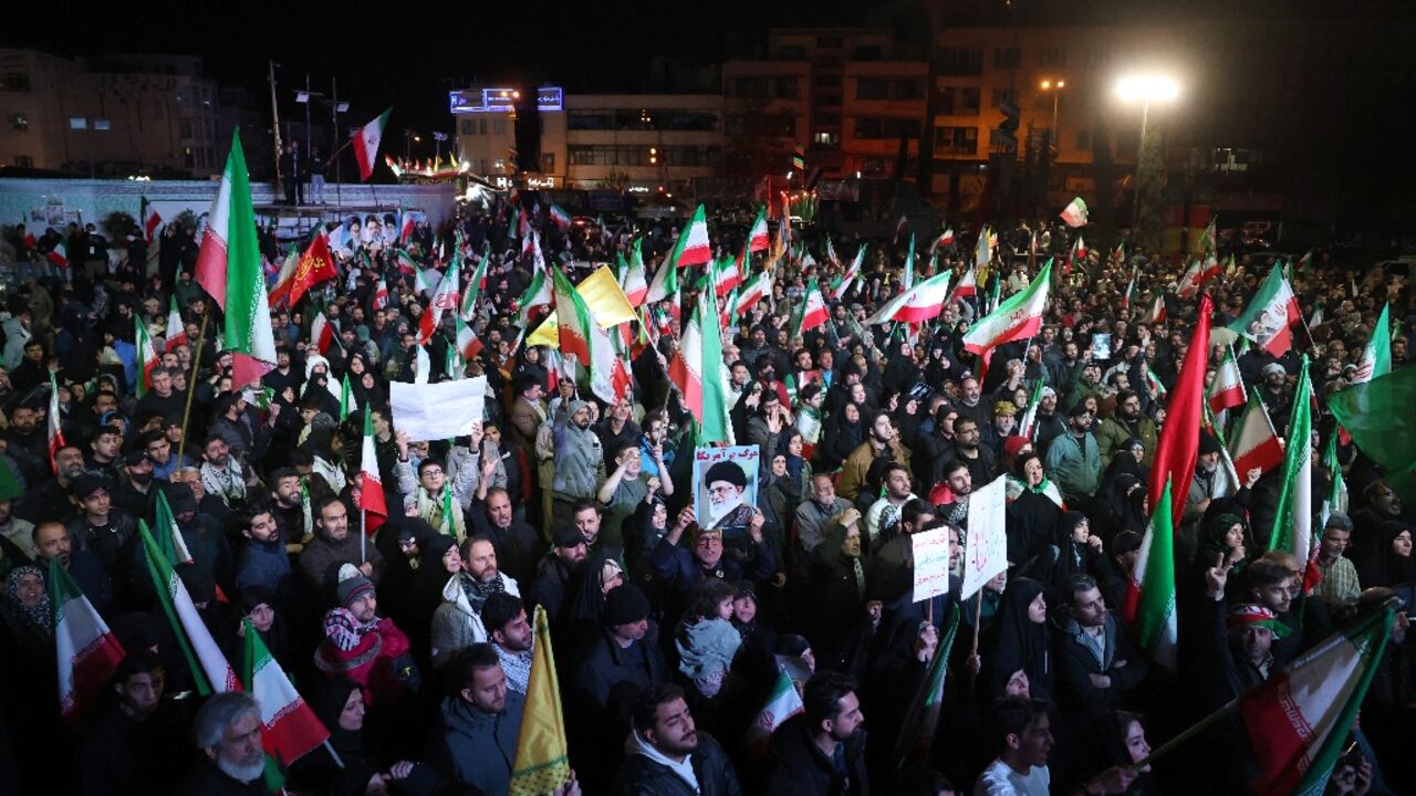 Iranians react after a ceasefire announcement at the Enqelab square in Tehran