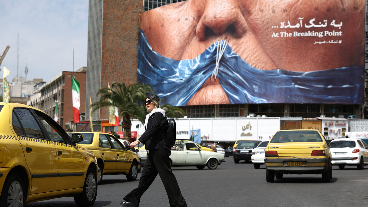 A woman walks past an anti-U.S. billboard depicting U.S. President Donald Trump and the Strait of Hormuz, in Tehran, Iran, May 2, 2026. Majid Asgaripour/WANA (West Asia News Agency) via REUTERS ATTENTION EDITORS - THIS PICTURE WAS PROVIDED BY A THIRD PARTY