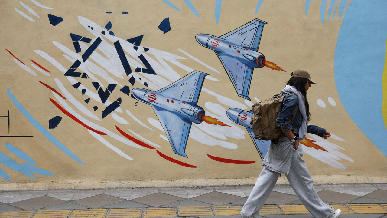 An Iranian woman walks next to an anti-Israeli mural on a street in Tehran, Iran, May 5, 2026. Majid Asgaripour/WANA (West Asia News Agency) via REUTERS
