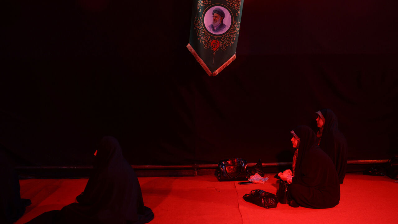 Iranian women pray next to a picture of the late Supreme Leader of Iran, Ayatollah Ali Khamenei, near his office in Tehran, Iran, May 6, 2026. Majid Asgaripour/WANA (West Asia News Agency) via REUTERS
