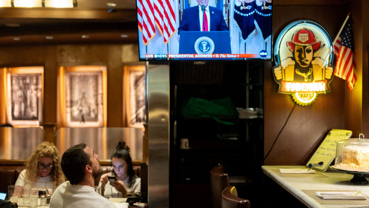 A customer watches U.S. President Donald Trump address the nation on the Iran crisis from the White House in Washington, D.C., on screen at Brooklyn Diner in Times Square, New York, U.S., April 1, 2026. REUTERS/David Dee Delgado/File Photo