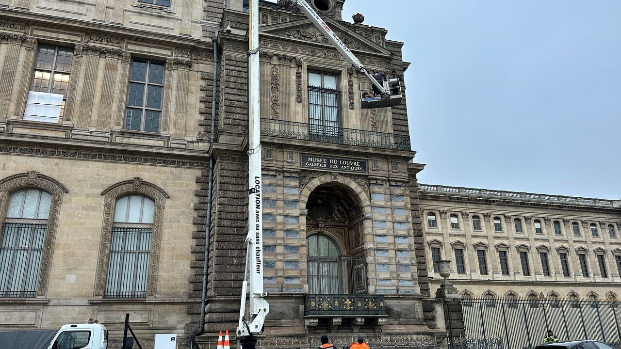 FILE PHOTO: Workers install a security grill at the window of the Louvre Museum, in Paris, France, December 23, 2025. REUTERS/Noemie Olive/File Photo