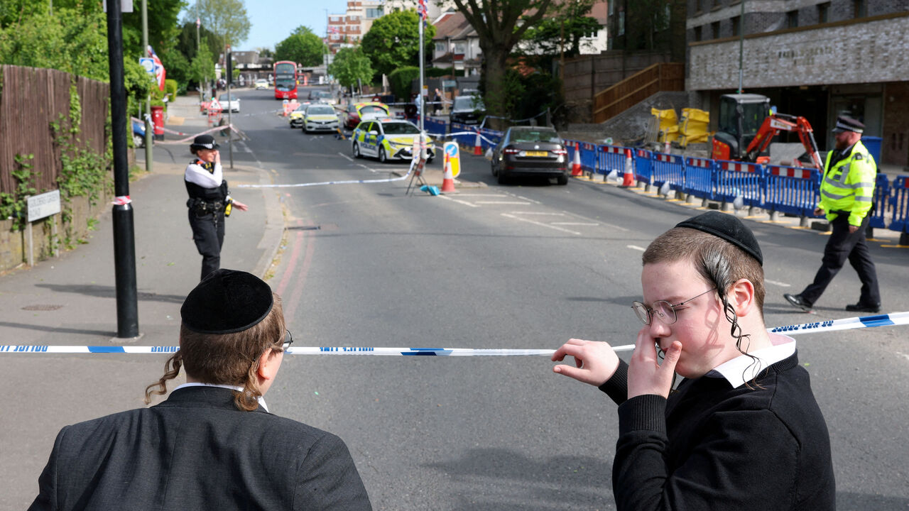 FILE PHOTO: Orthodox Jews stand by a police cordon, after a man was arrested following a stabbing incident in the Golders Green area, which is home to a large Jewish population, in London, Britain, April 29, 2026. REUTERS/Hannah McKay/File Photo