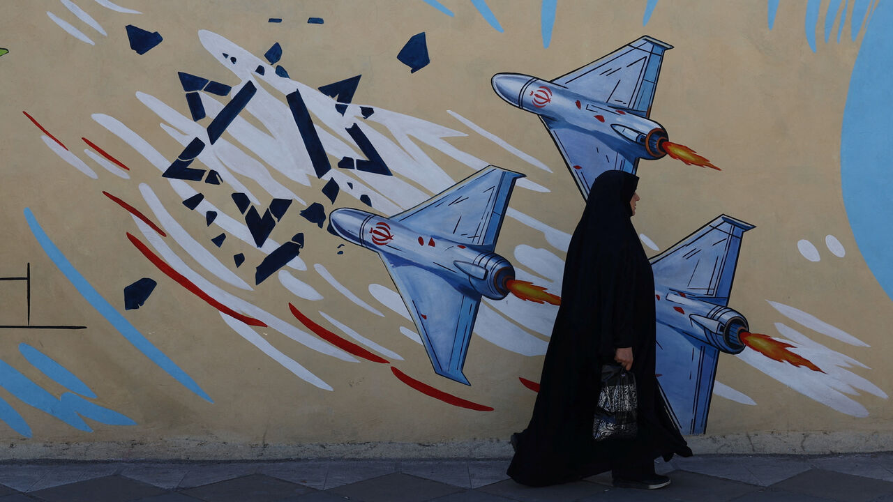 An Iranian woman walks next to an anti-Israeli mural on a street in Tehran, Iran, May 18, 2026. Majid Asgaripour/WANA (West Asia News Agency) via REUTERS