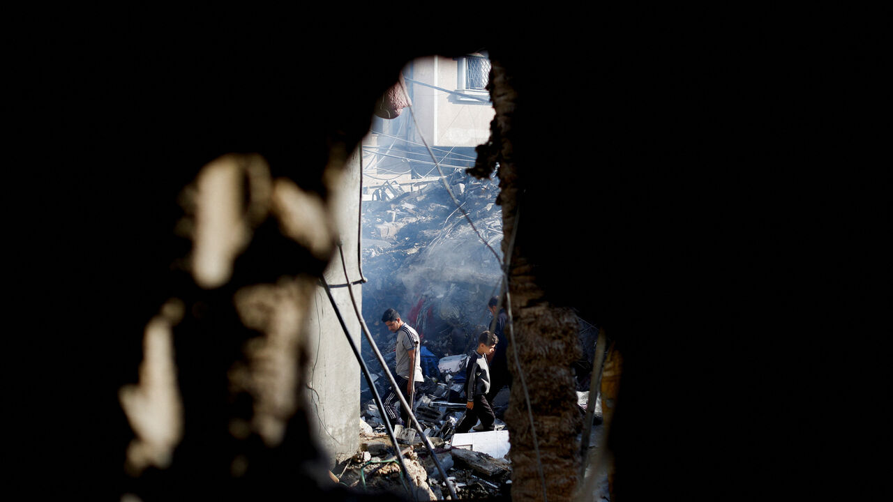 Palestinians inspect the site of an Israeli strike on a house that was pre-warned by the Israeli military to evacuate before the strike was carried out late on Saturday, in Deir al-Balah, in the central Gaza Strip, May 24, 2026. REUTERS/Mahmoud Issa