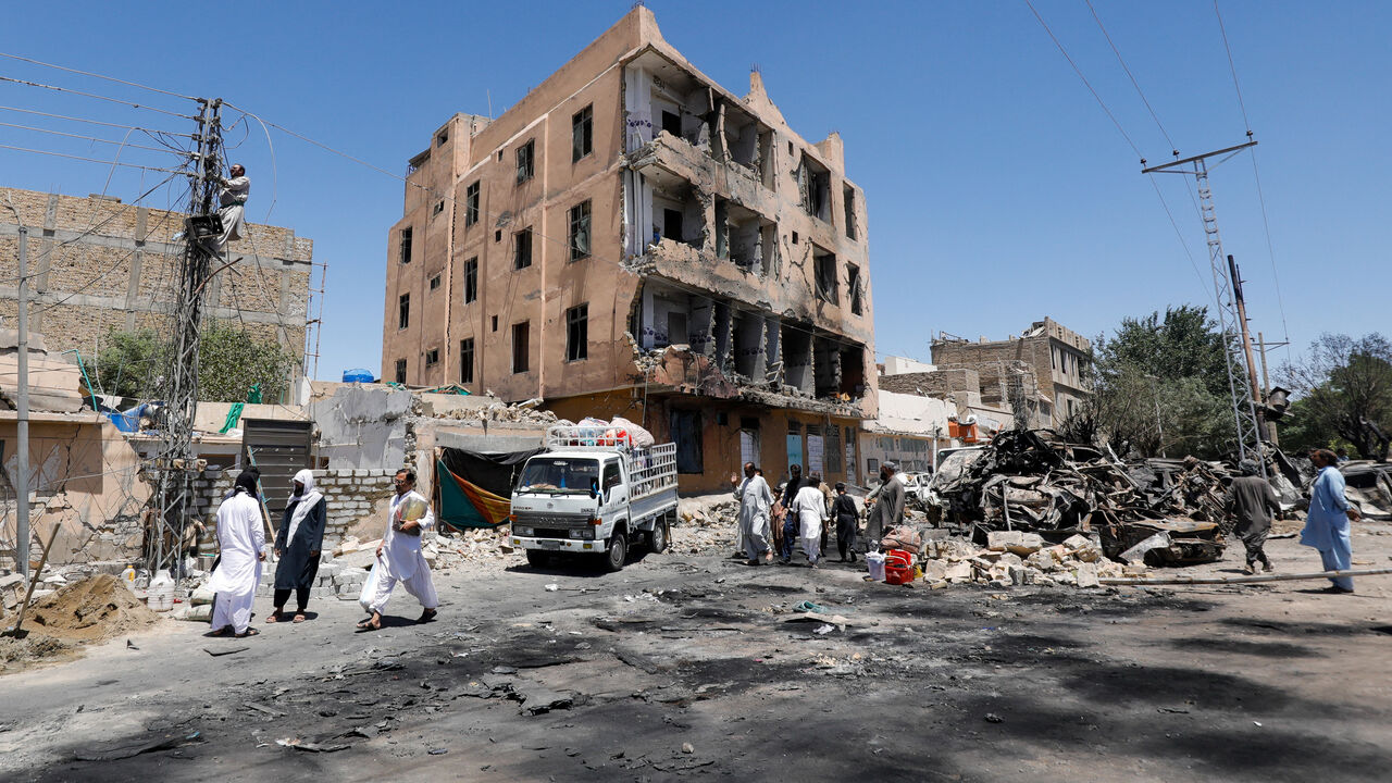 Residents walk past a damaged building, rubble and destroyed cars a day after a blast in Quetta, Pakistan May 25, 2026. REUTERS/Naseer Ahmed