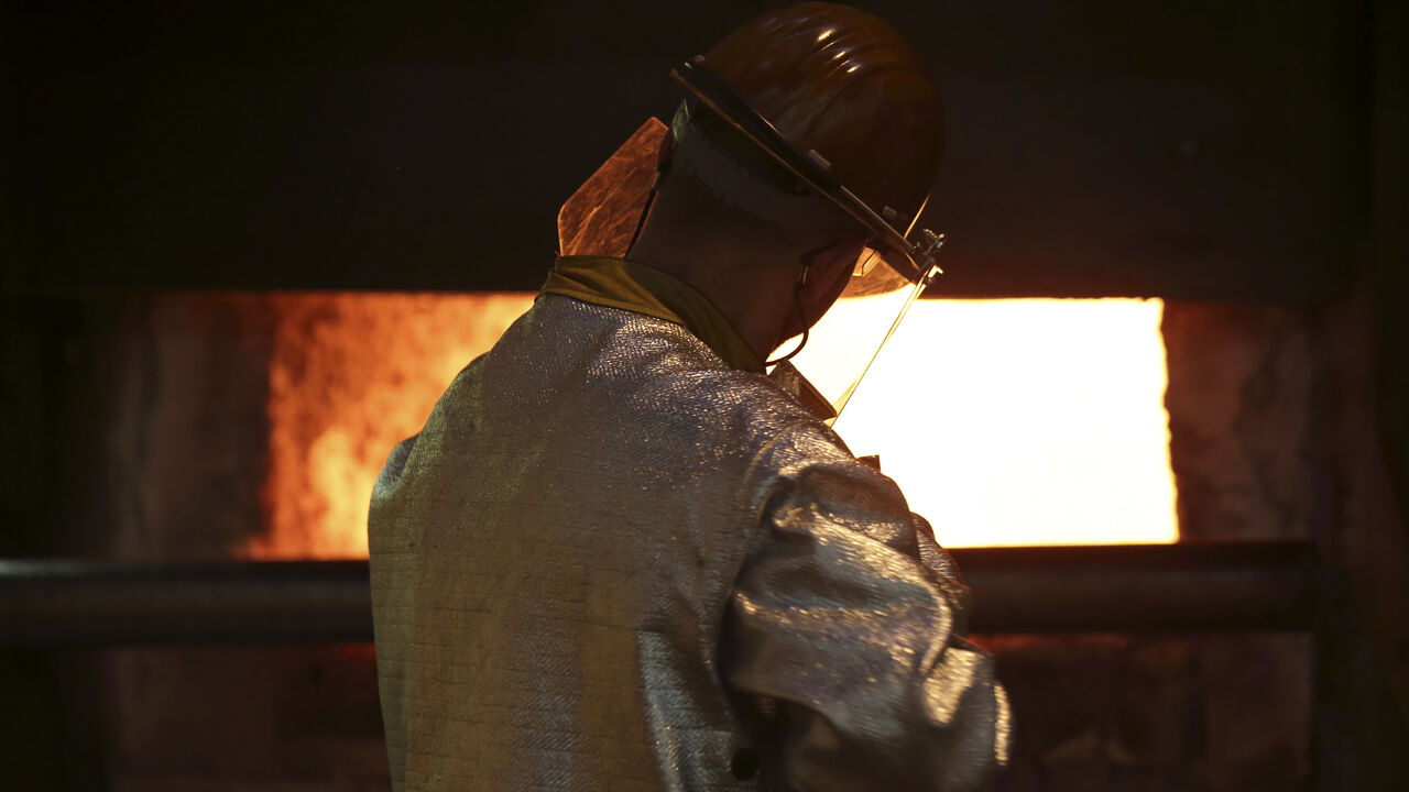 A worker cleans impurities from an aluminium furnace at the Renault factory in Cleon, Western France, July 20, 2015. The Renault plant constructs the R240 electrical car engine, with an autonomy of 240 kilometres, for its Zoe line of automobiles. The plant has a current production capacity of 50,000 engines that can be increased to 100,000 units. Picture taken July 20, 2015.   REUTERS/Philippe Wojazer