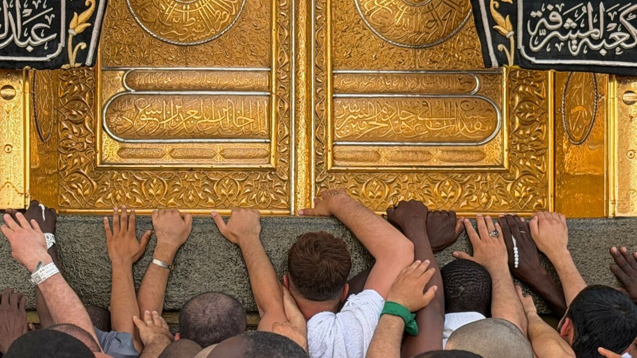 Worshippers touch the Kaaba, Islam's holiest shrine, at the Grand Mosque in Mecca ahead of this year's hajj