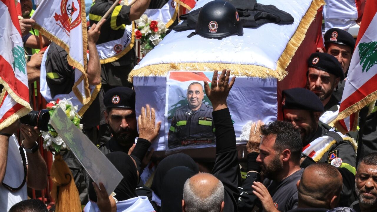 Fellow rescuers carry the coffins of two members of the civil defence who Lebanon said were killed in Israeli airstrikes