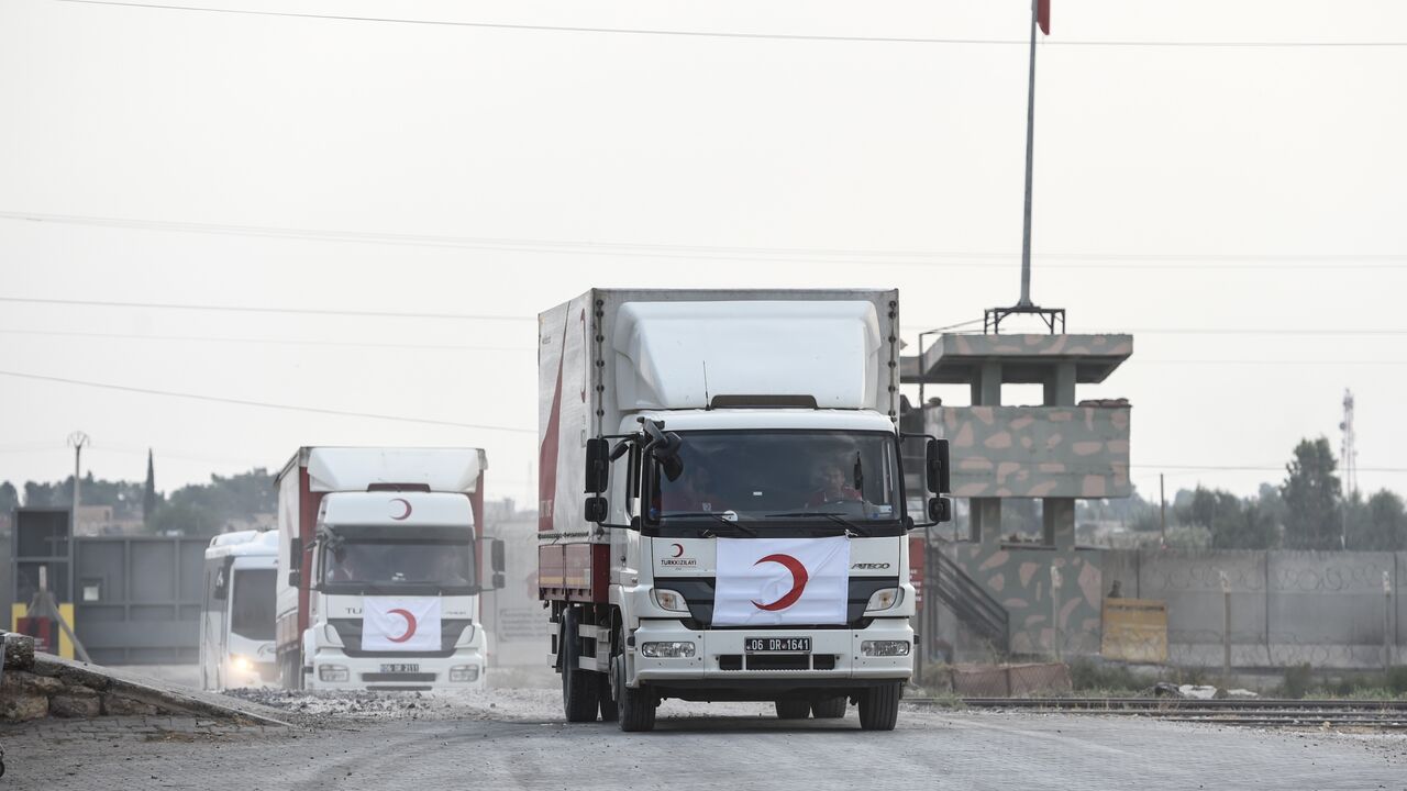 Turkish Red Crescent's cars and trucks cross the Turkish border as they leave the Syrian city of Tel Abyad on Oct. 19, 2019, in Akcakale, Turkey. 