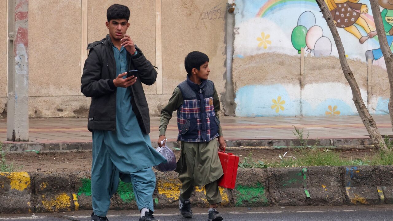 Baluch Iranian youths cross a street in Zahedan, in the southeastern province of Sistan-Baluchistan bordering Afghanistan, on Dec. 18, 2025.
