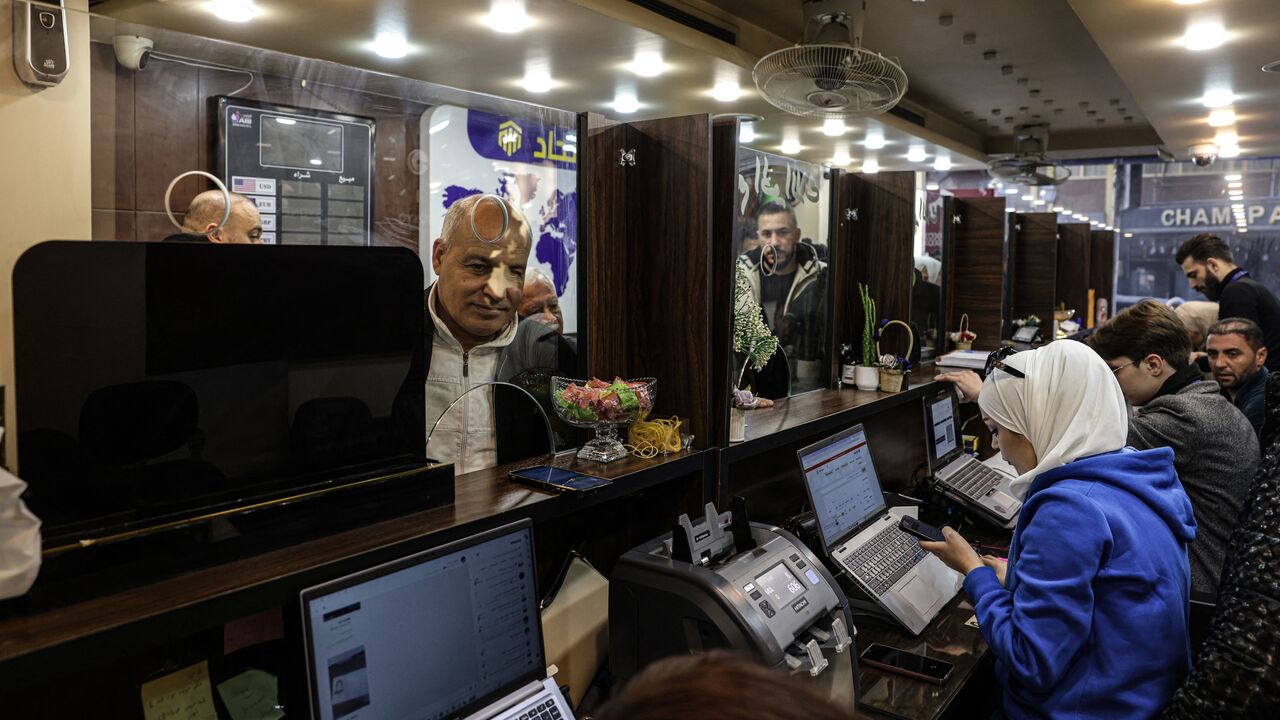 A Syrian citizen exchanges old banknotes for new notes released and distributed by the central bank, at a bank in the capital, Damascus, on Jan. 3, 2026.