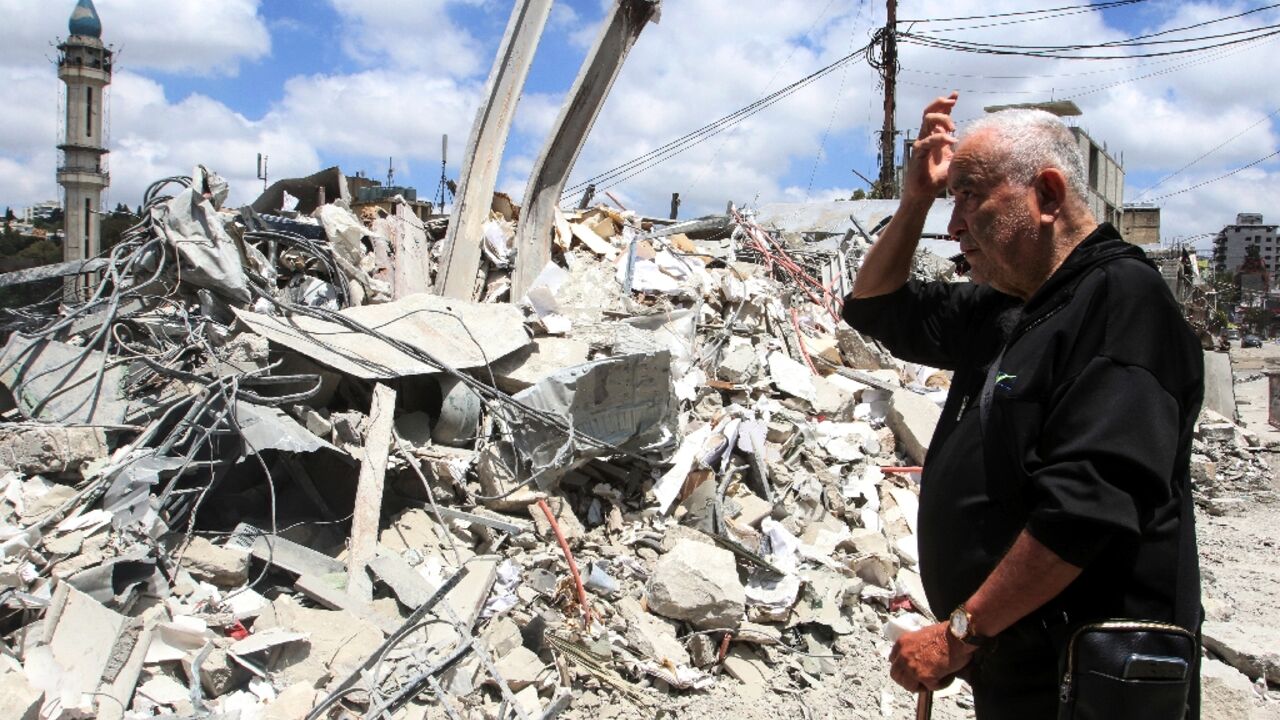 A man looks at the damage as residents displaced by fighting return to Nabatieh in southern Lebanon 