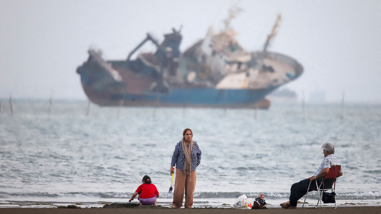 FILE PHOTO: People gather on a beach, as a vessel in the Strait of Hormuz is visible, near the beach of Bandar Abbas, Iran, May 31, 2026. Amirhosein Khorgooi/ISNA/WANA (West Asia News Agency) via REUTERS/File Photo