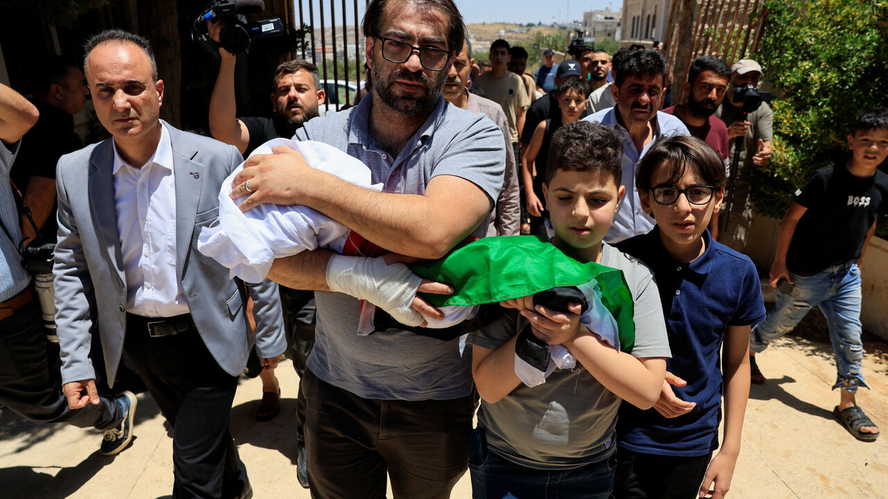 Father and brother of Sam Abu Haykal, a 7-month-old Palestinian child who was killed by Israeli soldiers, carry his body during his funeral in Hebron in the Israeli-occupied West Bank, June 6, 2026. REUTERS/Mussa Qawasma