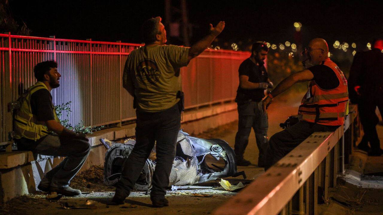 Israeli security and rescue personnel work next to a part of a projectile following a missile attack from Iran towards Israel in northern Israel, June 8, 2026. REUTERS/Shir Torem