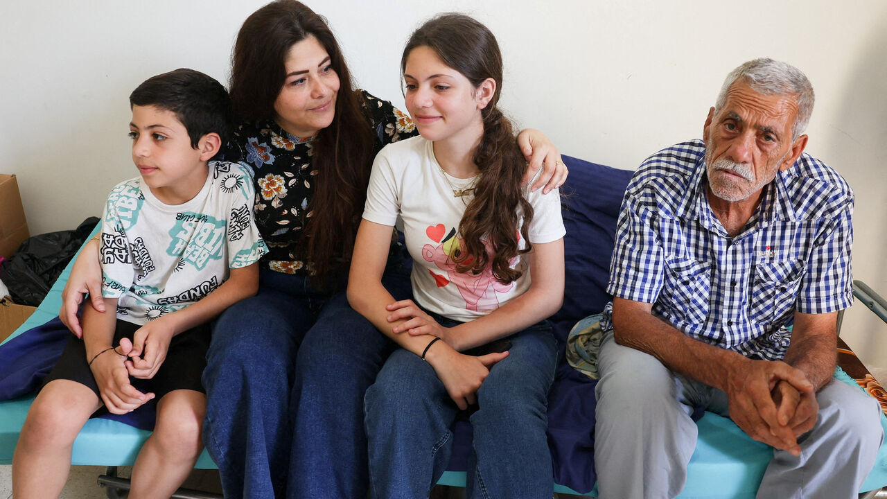 FILE PHOTO: Darine Al Jouny Safadi, 38, her children Salma and Eliya, and her father Youssef Al Jouny, a Christian family displaced from Tyre, southern Lebanon, sit in a room where they take refuge at the House of Saint Anne for Youth, overseen by the Greek Melkite Catholic Patriarchate, in Rabweh, Lebanon, June 10, 2026. REUTERS/Mohamed Azakir/File Photo