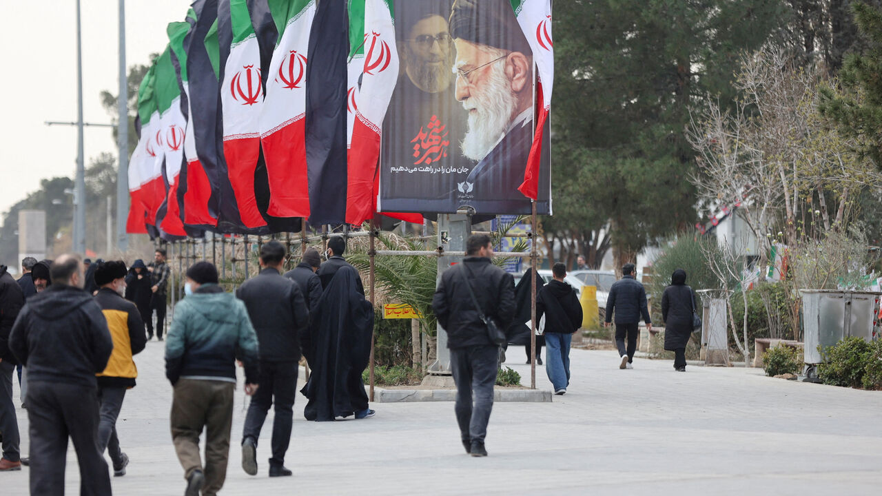 FILE PHOTO: People walk along a street with Iranian flags and a poster with images of Iran's late Supreme Leader Ayatollah Ali Khamenei, amid the U.S.-Israeli conflict with Iran, in Tehran, Iran, March 9, 2026. Majid Asgaripour/WANA (West Asia News Agency) via REUTERS/File Photo