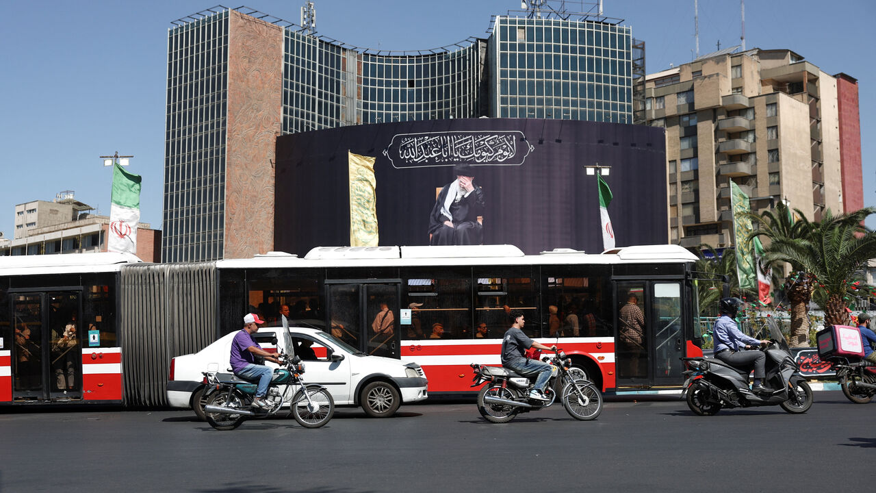 People drive past a billboard with a picture of the late Iran's Supreme Leader Ayatollah Ali Khamenei, after U.S. and Iranian officials said they had reached a deal to end their war and reopen the Strait of Hormuz, in Tehran, Iran, June 15, 2026. Majid Asgaripour/WANA (West Asia News Agency) via REUTERS