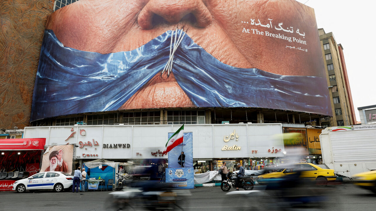 FILE PHOTO: People drive past an anti-U.S. billboard depicting U.S. President Donald Trump and the Strait of Hormuz, in Tehran, Iran, May 17, 2026. Majid Asgaripour/WANA (West Asia News Agency) via REUTERS ATTENTION EDITORS - THIS PICTURE WAS PROVIDED BY A THIRD PARTY/File Photo