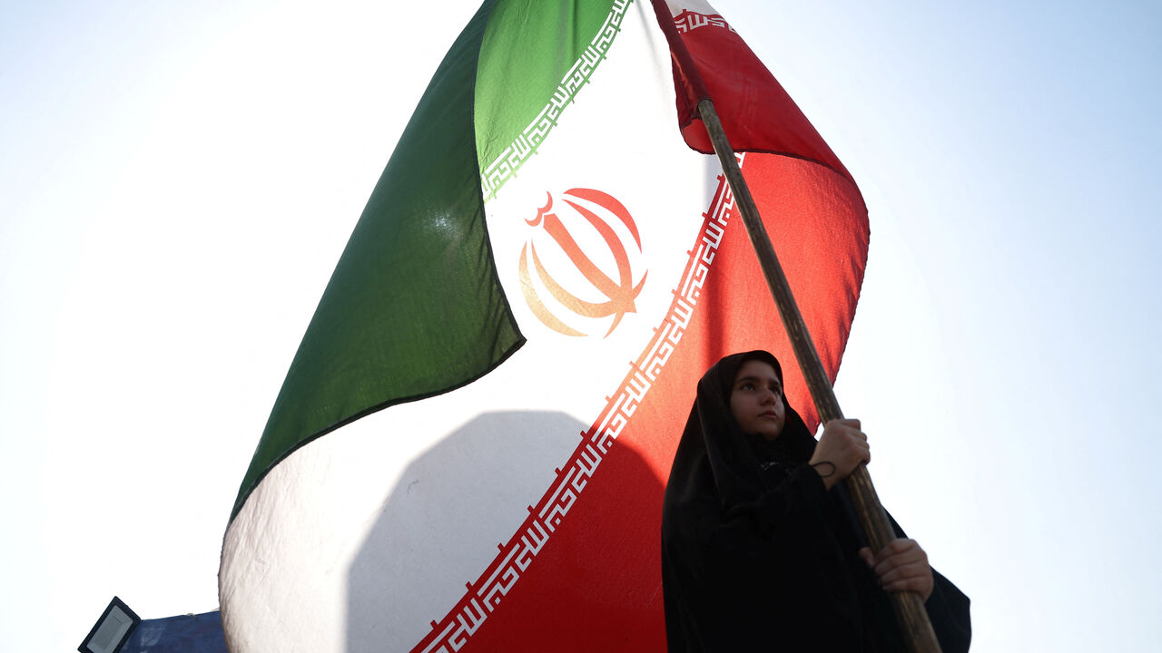A woman holds an Iranian flag on a street in Tehran, Iran, June 10, 2026. Majid Asgaripour/WANA (West Asia News Agency) via REUTERS