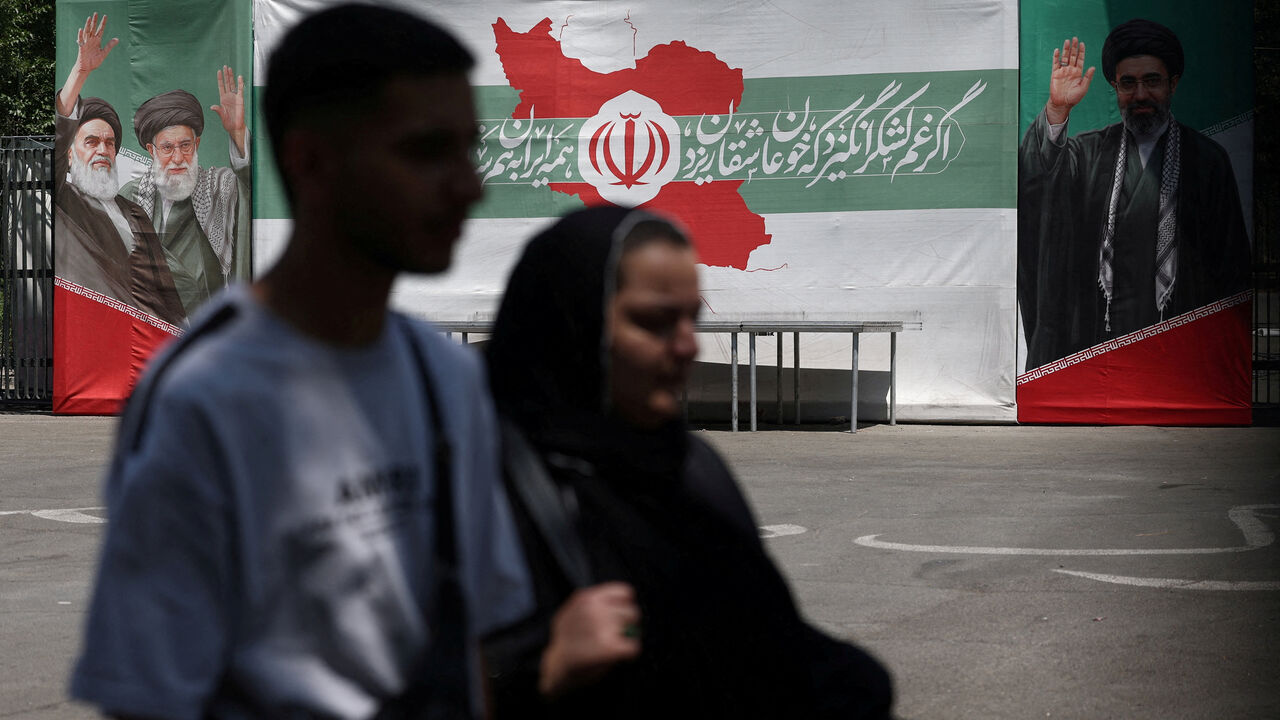 FILE PHOTO: People walk past a banner with pictures of the late leader of the Islamic Revolution, Ayatollah Ruhollah Khomeini, the late Iran's Supreme Leader Ayatollah Ali Khamenei, and Iran's Supreme Leader Mojtaba Khamenei, on a street in Tehran, Iran, June 9, 2026. Majid Asgaripour/WANA (West Asia News Agency) via REUTERS