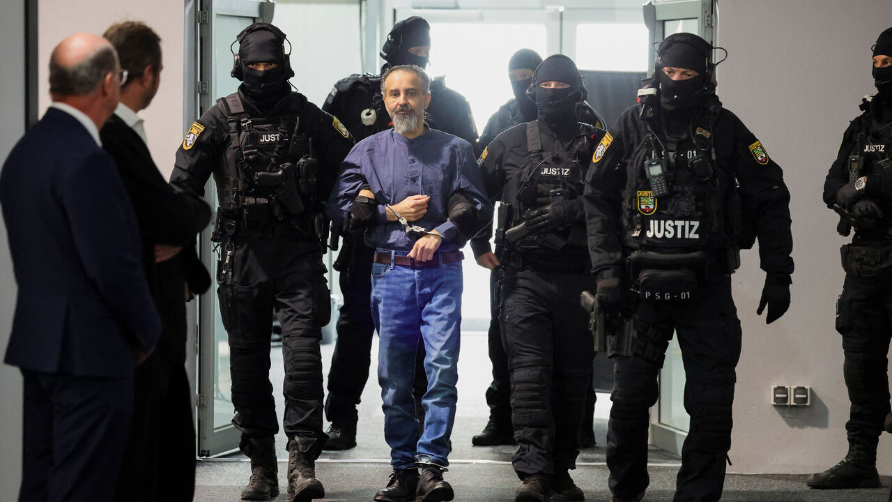 Suspect Taleb al-Abdulmohsen, a doctor from Saudi Arabia who faces charges of murder, attempted murder and dangerous interference with road traffic, is escorted by security officers as he attends his trial for the Magdeburg Christmas market attack, at a regional court in Magdeburg, Germany, June 26, 2026. REUTERS/Fabrizio Bensch