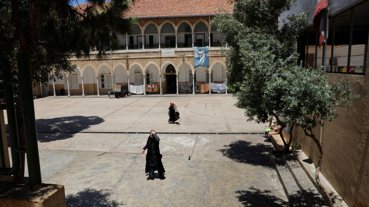 Women walk at a school that has been turned into a shelter for displaced families, following a deal between the United States and Iran, in Beirut, Lebanon, June 16, 2026. REUTERS/Khalil Ashawi