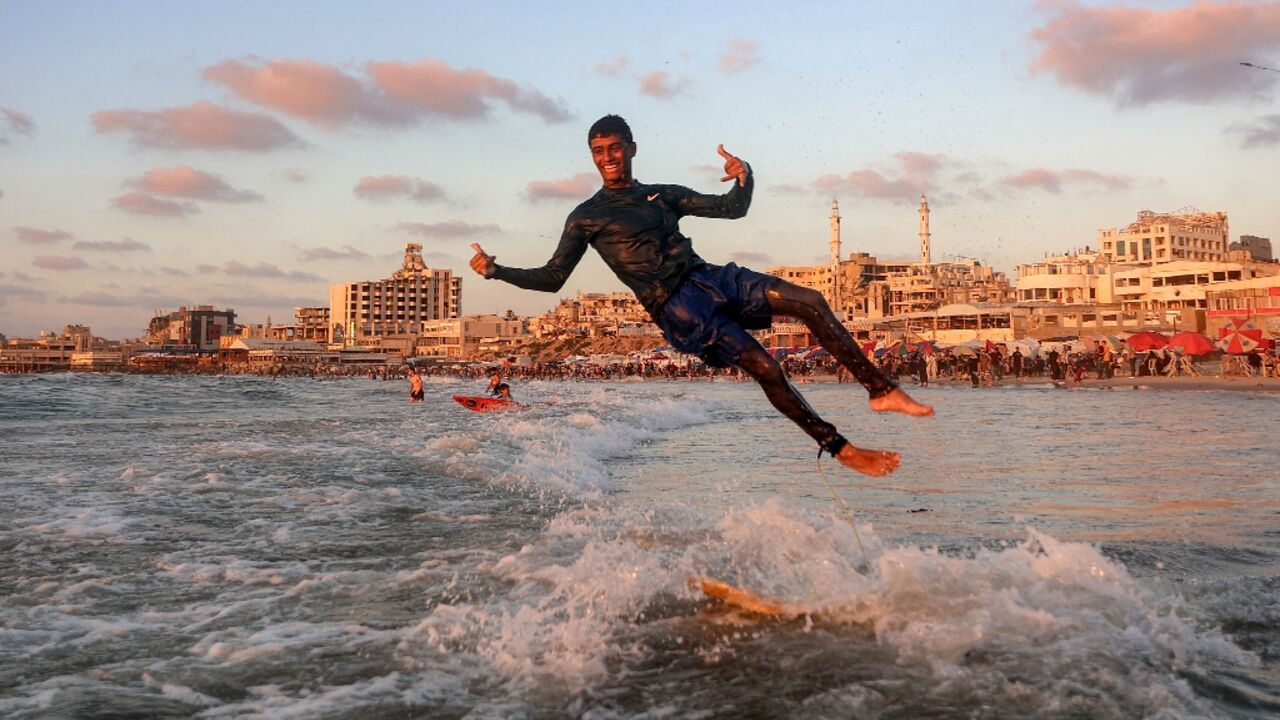 Surfers still ride the waves off Gaza City, despite the devastation wreaked on the Palestinian territory during the recent conflict 