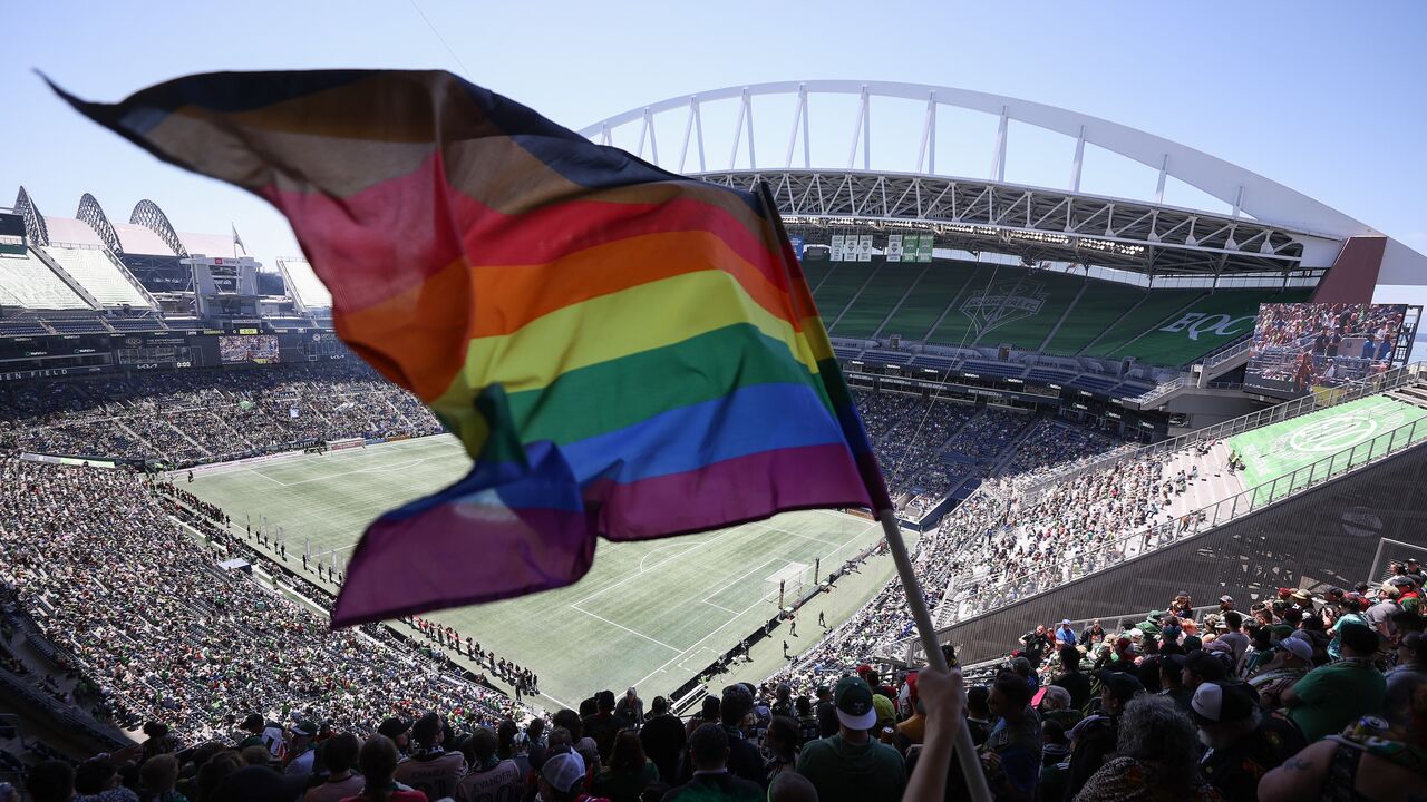 A fan waves a Pride flag before the game between the Seattle Sounders and the Portland Timbers at Lumen Field on June 3, 2023, in Seattle, Washington. 