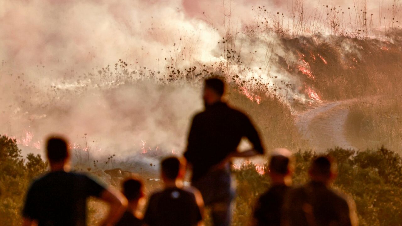 Palestinians watchrf as a fire blazed near the village of Tell, adjacent to the Israeli settlement of Havat Gilad, west of Nablus in the occupied West Bank