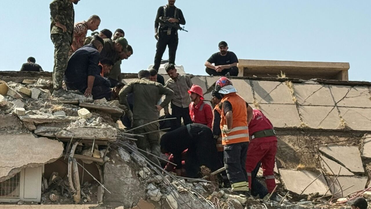 Iraqi security forces and emergency personnel worked to recover the woudned at the site of US-Saudi strikes that targeted a base belonging to the Hashed al-Shaabi forces in Iraq's Diyala province