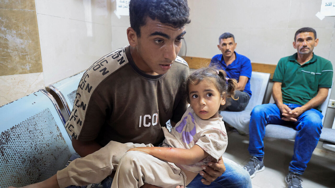 A man carries a girl as Palestinians wounded in an Israeli strike on a tent, according to medics, receive medical treatment at Nasser Hospital in Khan Younis, in the southern Gaza Strip, July 8, 2026. REUTERS/Haseeb Alwazee