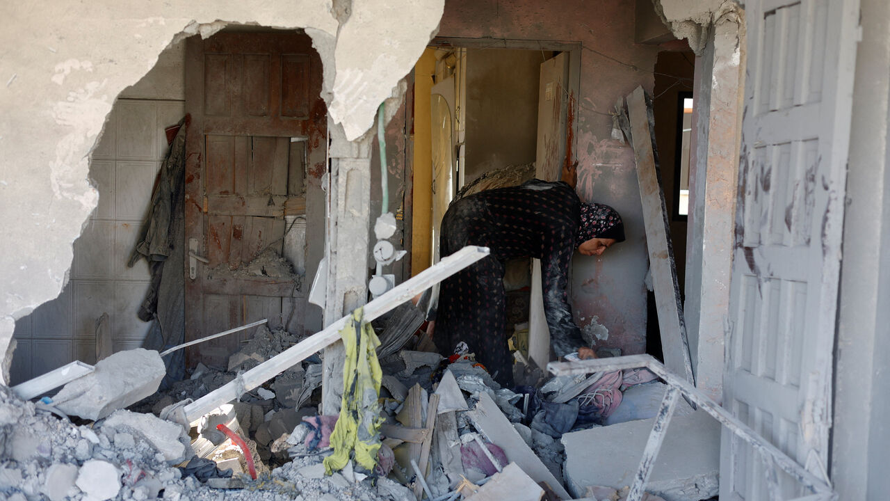 A Palestinian woman inspects the site of an Israeli strike on a house that was pre-warned by the Israeli military to evacuate before the strike was carried out late on Wednesday, in Al-Nuseirat refugee camp, in the central Gaza Strip,  July 16, 2026. REUTERS/Mahmoud Issa