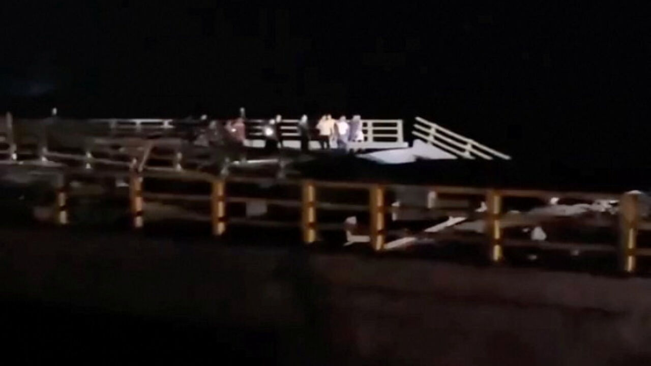 People stand near a damaged portion of a bridge in the aftermath of a strike, in Bandar Khamir, Hormozgan province, Iran July 16, 2026 in this screen grab obtained from social media video. Social Media/via REUTERS