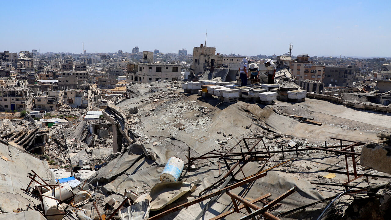Palestinian beekeepers work on beehives installed on top of a ruined building, amid widespread destruction and a shortage of space, in Gaza City, June 25, 2026. REUTERS/Ebrahim Hajjaj