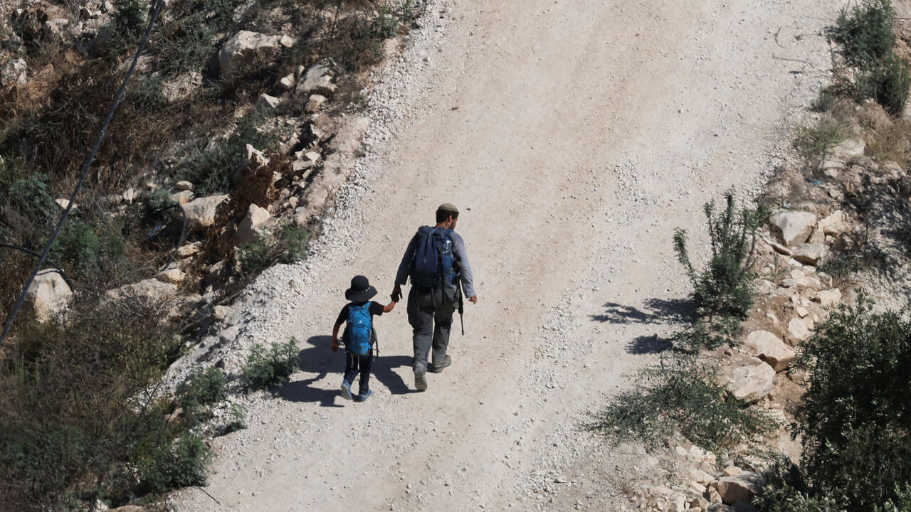 Israeli settlers approach the Palestinian village of Tal in the Israeli-occupied West Bank, July 31, 2026. REUTERS/Ammar Awad
