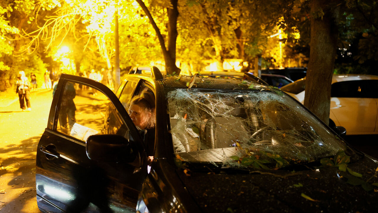 A person gets out of a damaged vehicle near the site of an apartment building hit by a Russian missile strike, amid Russia's attack on Ukraine, in Kyiv, Ukraine, August 1, 2026. REUTERS/Gleb Garanich