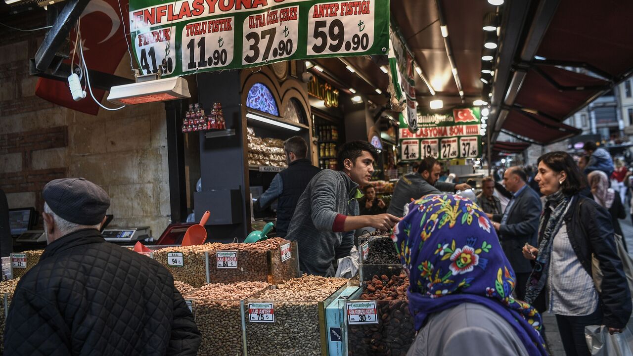 Vendors sell dry food as people shop by a banner reading " No to Inflation" near the New Mosque area in Istanbul's Eminonu district on Nov. 6, 2018. 